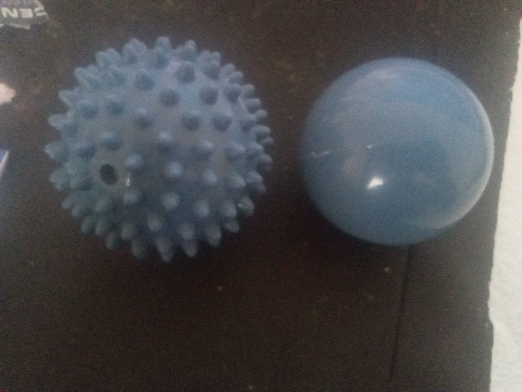 Twee blauwe massageballen op een donkere ondergrond